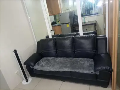 a black leather couch sitting in a living room at Nice and Simple 1 Bedroom in Shell Residences in Manila