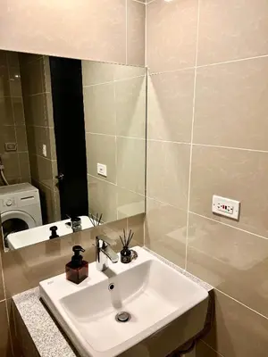 a bathroom with a sink and a mirror at Lovely 1 Bedroom City View in Uptown BGC in Manila