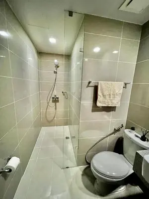 a bathroom with a shower and a toilet and a sink at Lovely 1 Bedroom City View in Uptown BGC in Manila