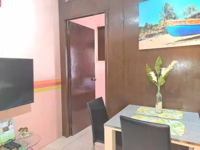 a dining room with a table with a vase on it at Affordable Condo for Rent near Emperor Events Place in Cainta