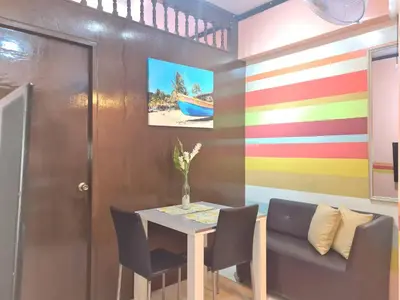 a dining room with a table and chairs and a colorful wall at Affordable Transient along Ortigas Ext near Cainta/Pasig in Cainta