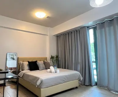a bedroom with a bed and a large window at 2 Palm Tree Villas - Manila Terminal 3 Airport Pasay in Manila
