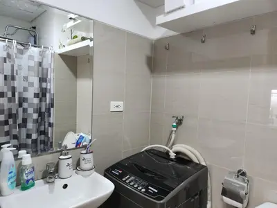 a bathroom with a sink and a toilet and a mirror at Jana@ShoreC2 in Manila