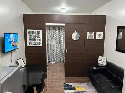 a living room with a couch and a door at Air Residences - 1Bedroom Unit with Balcony - Wifi & Netflix in Manila