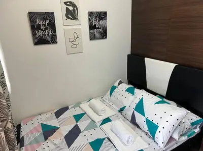 a bedroom with a bed with a comforter and pillows at Air Residences - 1Bedroom Unit with Balcony - Wifi & Netflix in Manila