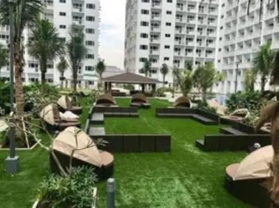 a park with benches and palm trees and buildings at SHELL RESIDENCE c7 shortwalk MALL OF ASIA in Manila