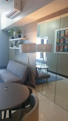 a living room with a couch and a table at Uptown Parksuites Tower 1 BGC in Manila
