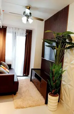 a living room with a couch and a plant at MOA S Residences 1BR Condo Stunning Boutique T3 in Manila