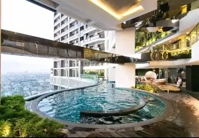 a large swimming pool in the middle of a building at Makati - Sleeps 2 - Pool - Cinema - Gym - Garden in Manila