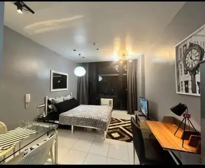 a living room with a bed and a desk in it at Makati - Sleeps 2 - Pool - Cinema - Gym - Garden in Manila