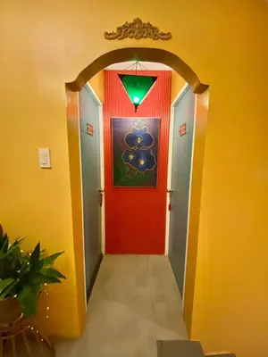 a hallway with a red door and a green light at Rain Airport Bed and Breakfast in Manila