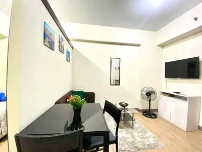 a living room with a table and a dining room at staycation affordable alabang in Manila