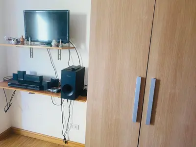 a wooden cabinet with a television on a shelf at Azure Residence B1 Free wi-fi Near Sm Mall Airport in Manila