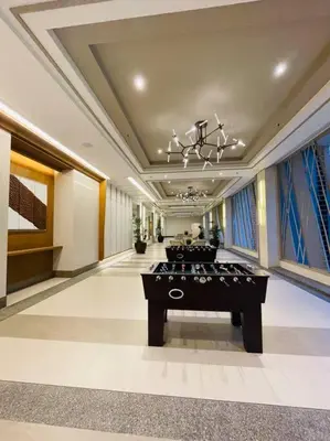a lobby with a table in the middle of a room at Stylish 1 bedroom condo with pool view and Fast WIFI in Manila