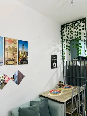 a dining room with a table and a couch at OneTiago Staycation - Spring Residences Paranaque in Manila