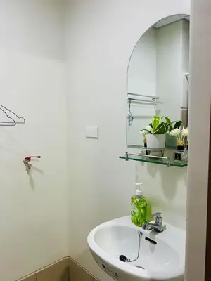 a white bathroom with a sink and a mirror at OneTiago Staycation - Spring Residences Paranaque in Manila