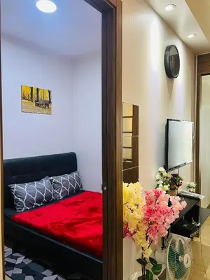 a room with a bed with a red blanket at OneTiago Staycation - Spring Residences Paranaque in Manila