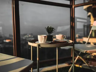 a table with two coffee cups and a potted plant on it at The Radiance Manila Bay - Modern 1-Bedroom Condo with View in Manila