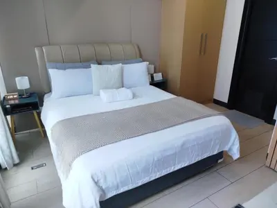 a bedroom with a large bed with white sheets at Cozy 1BR UPTOWN PARKSUITES Tower1 BGC in Manila