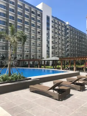 a hotel with a swimming pool in front of a building at Salamat Place Original in Manila