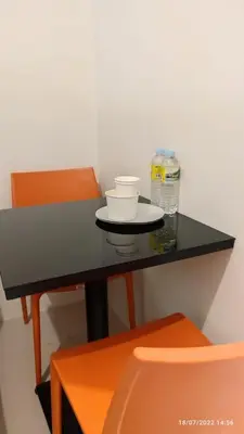 a black table with a bottle of water and a chair at Jazz Residences (Destina Stays)Makati, Metro Manila in Manila