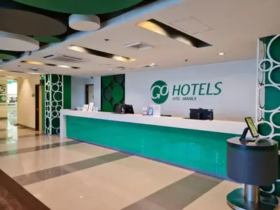 a lobby of a hotel with a reception counter at Go Hotels Otis - Manila in Manila