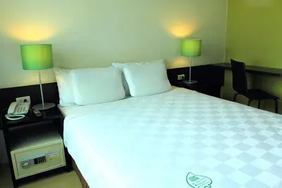 a bedroom with a bed with two lamps and a phone at Go Hotels Plus Mandaluyong in Manila