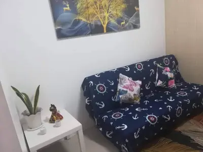 a blue couch with pillows on it next to a table at Alatonplace sea residences in Manila