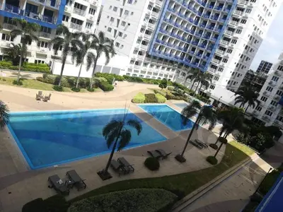 a large swimming pool in front of a large building at Alatonplace sea residences in Manila
