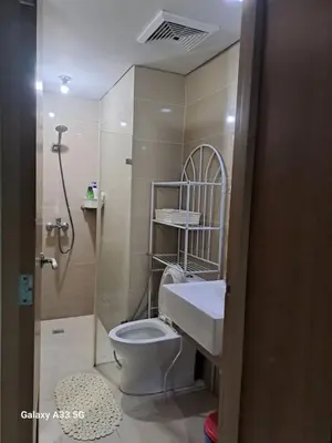 a bathroom with a toilet and a sink and a shower at MRMCONDOTEL cluster 1 2H in Manila