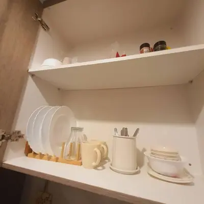 a kitchen shelf with plates and utensils on it at SMDC Coast Residences Lovely Fully-furnished 1 BR Condo with pool in Manila