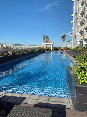 a large swimming pool in front of a building at SMDC Coast Residences Lovely Fully-furnished 1 BR Condo with pool in Manila
