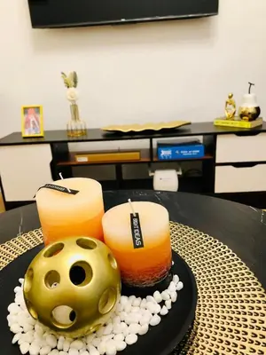 a table with two candles and a ball on it at Avida Tower Sucat, comfortable studio type in Manila