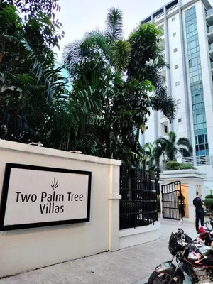 a sign for two palm tree villas in front of a building at RQUI CONDOTEL NEWPORT PASAY in Manila