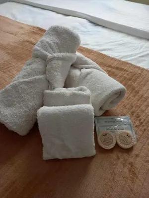 a towel on top of a bed with a medal at Beacon Makati Condo Free POOL Access FREE WIFI 100mbps & FREE Netflix in Manila