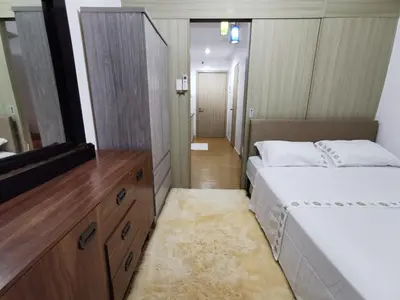 a bedroom with two beds and a flat screen tv at Ethan's Pad Nr. BGC in Manila