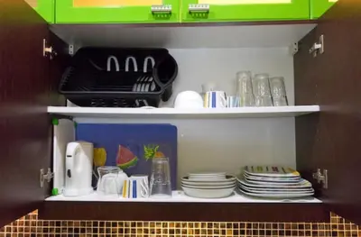 a pantry with plates and dishes on a shelf at BalaiB1 Cozy Studio in Ortigas Center in front of Galleria in Manila