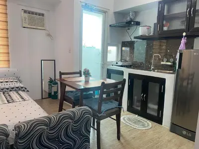 a living room with a table and a kitchen at affordable staycation alabang in Manila