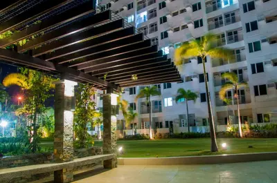 a large building with a bench and palm trees at affordable staycation alabang in Manila