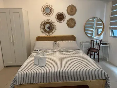 a bedroom with a bed with two towels on it at Telly's Studio Across NAIA3 in Manila