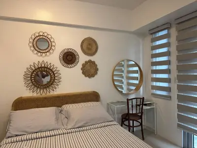 a bedroom with a bed and mirrors on the wall at Telly's Studio Across NAIA3 in Manila