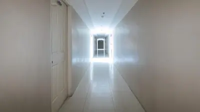 an empty hallway with a door and a window at RedDoorz @ Melbourne Suites Makati in Manila