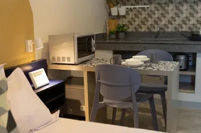 a kitchen with a table with chairs and a microwave at Hive Manila Guesthouse -Netflix,400mbps WI-FI in Bacoor