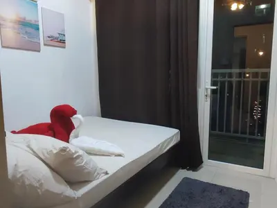 a bedroom with a bed with a red blanket on it at Sweet Stays 888 in Manila