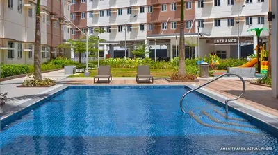 a swimming pool in a building with two chairs at Staycation ni Inday in Trece Martires