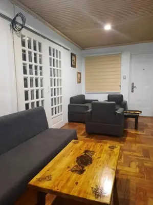 a living room with two couches and a wooden table at Omotenashi House of Santa Rosa City Laguna in Caingin