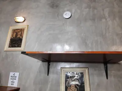 a shelf with two pictures and a clock on a wall at Omotenashi House of Santa Rosa City Laguna in Caingin