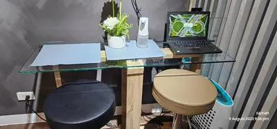 a glass desk with a laptop computer and a stool at SMDC AIR RESIDENCES in Manila