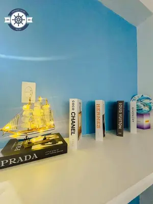 a book shelf with a model of a boat on it at Ocean theme Navy Blue Deluxe Suite with PS4 and Balcony overlooking Manila Bay and Manila Zoo plus near Manila Yacht Club and Star City in Manila