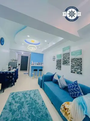 a living room with a blue couch and a kitchen at Ocean theme Navy Blue Deluxe Suite with PS4 and Balcony overlooking Manila Bay and Manila Zoo plus near Manila Yacht Club and Star City in Manila